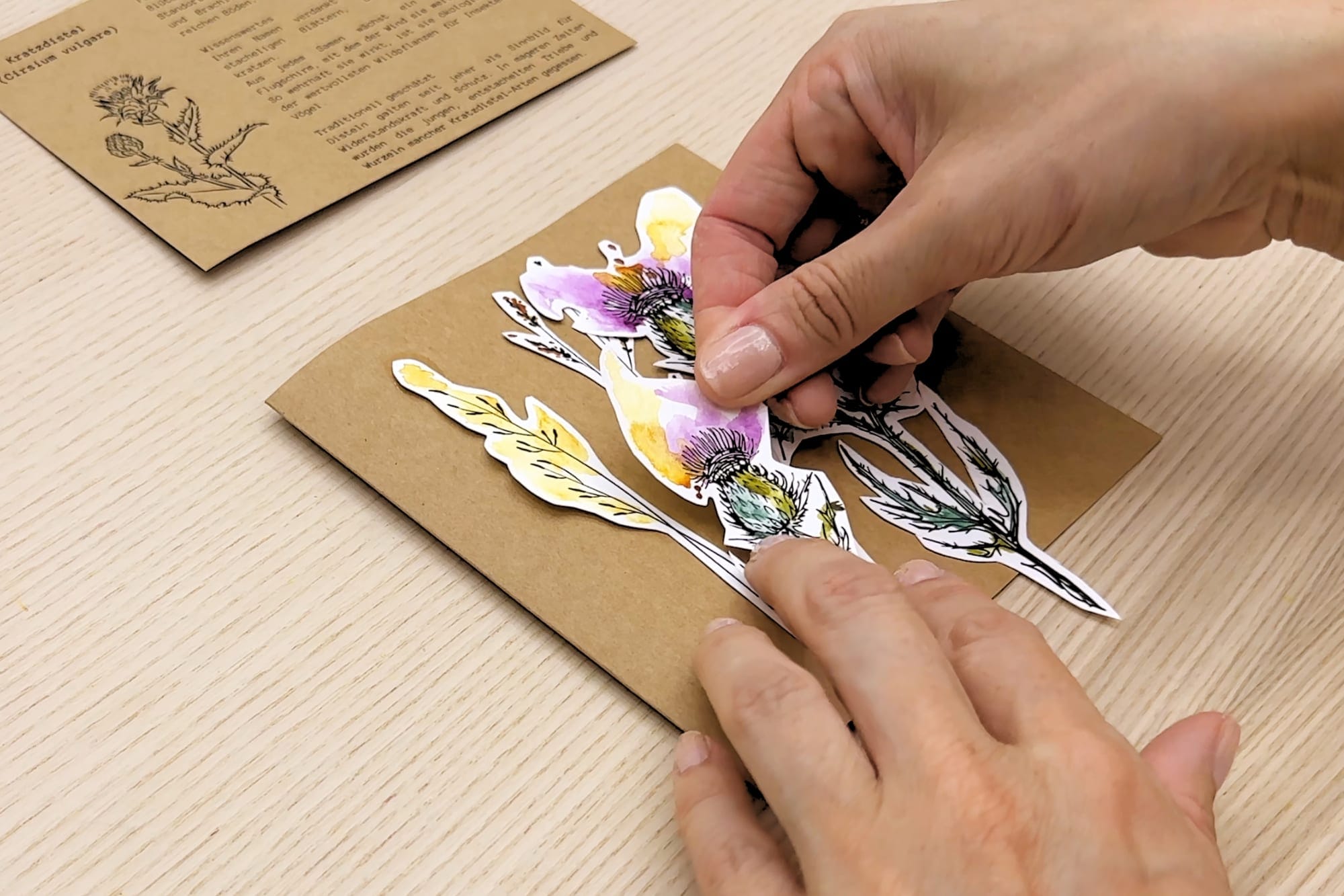 The cut-out thistles are glued onto the folding card in layers